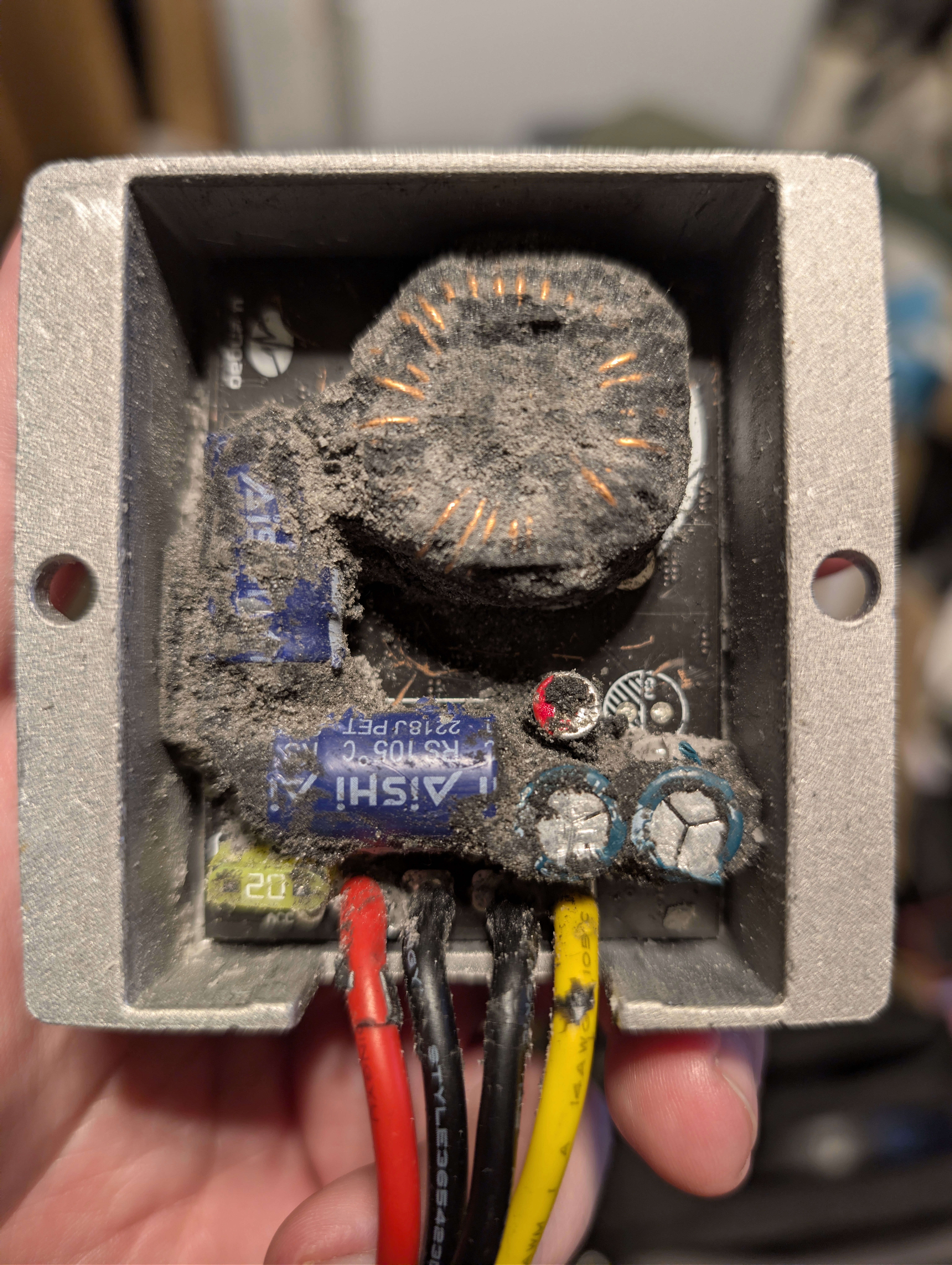 One of the blown DC-DC converters with its resin scraped out by me to determine why it failed